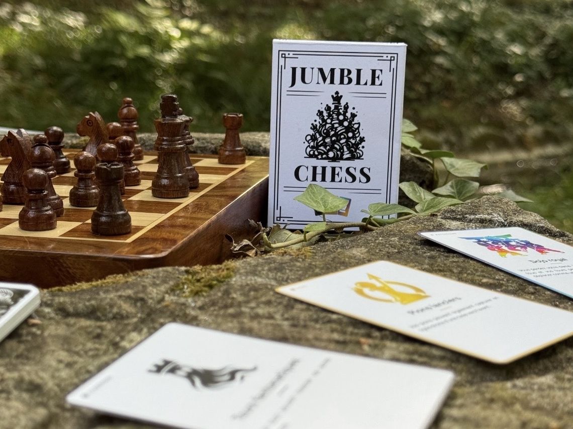 Boîte Jumble Chess posée à côté d’un échiquier en bois et de cartes modificateurs